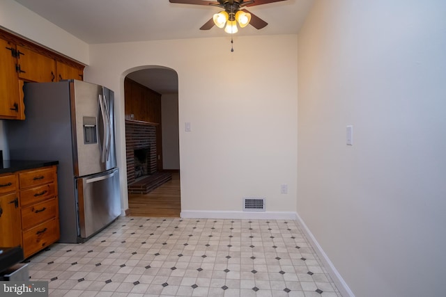 kitchen featuring ceiling fan, stainless steel fridge with ice dispenser, and a fireplace