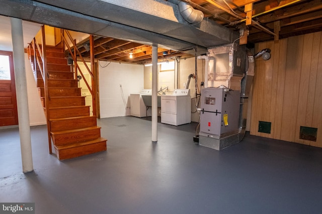 basement with independent washer and dryer, wooden walls, and heating unit