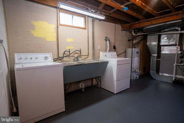 laundry area featuring washing machine and dryer, water heater, sink, and heating unit