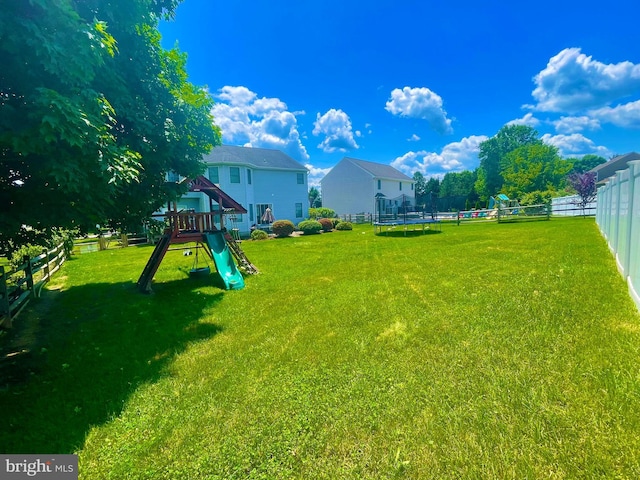 view of yard featuring a playground and a trampoline