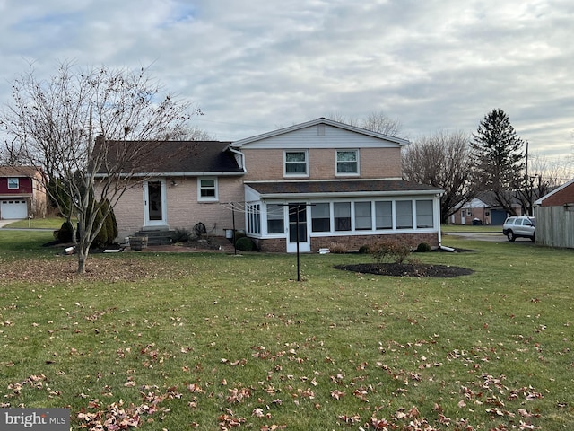 view of front facade featuring a sunroom and a front lawn