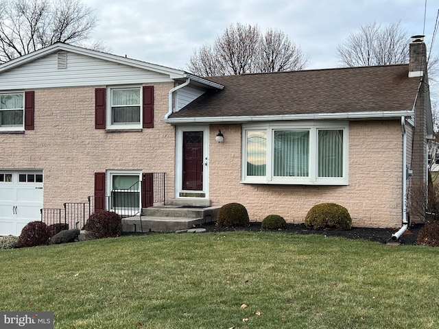 tri-level home with a garage and a front lawn