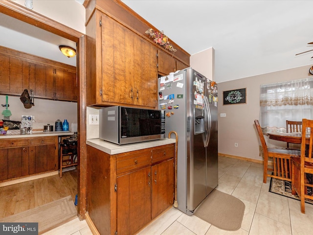 kitchen with light tile patterned floors and stainless steel appliances