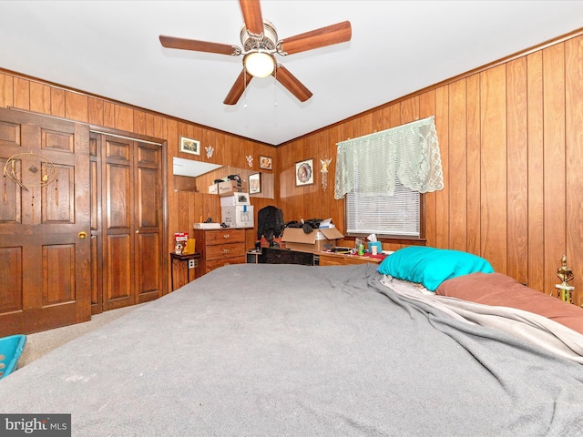 bedroom featuring carpet flooring, ceiling fan, and wood walls