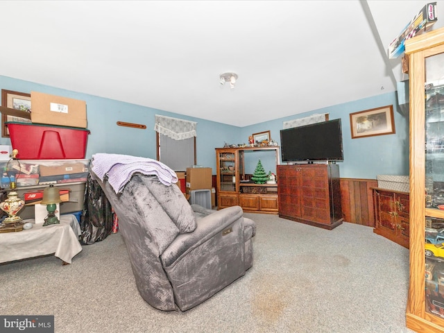 carpeted living room with wooden walls