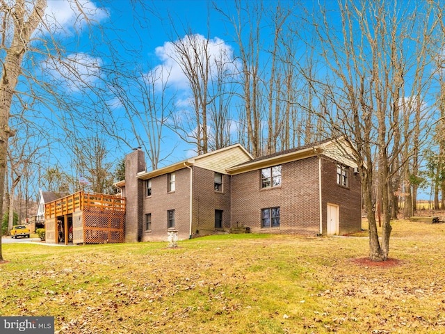 rear view of property featuring a yard and a deck