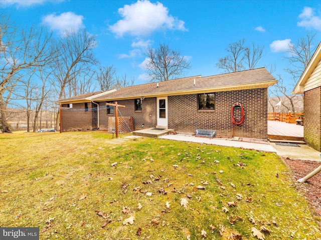 rear view of house with a yard and a wooden deck