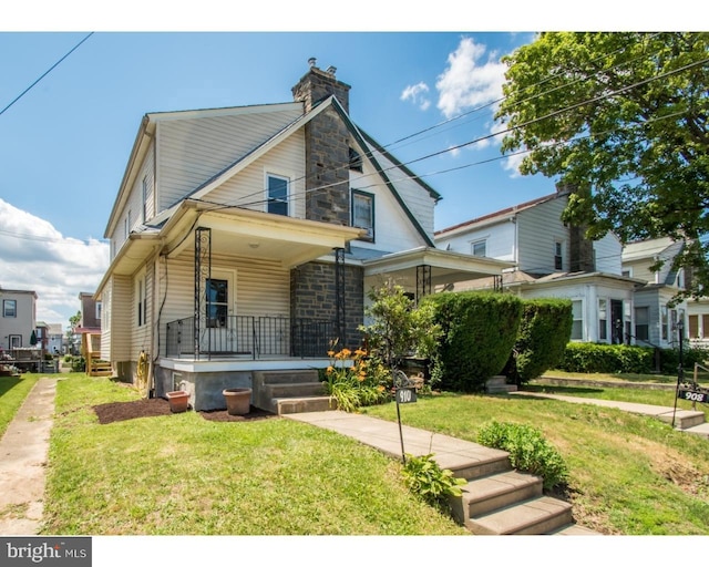 view of front of property with covered porch and a front yard