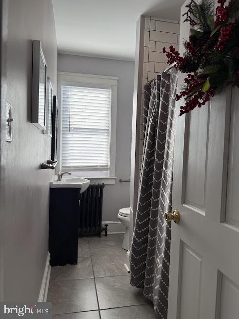 bathroom featuring toilet, radiator heating unit, vanity, and tile patterned flooring