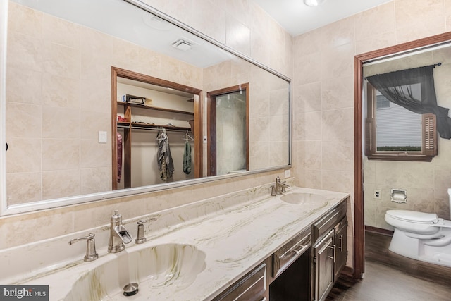 bathroom featuring hardwood / wood-style floors, vanity, toilet, and tile walls