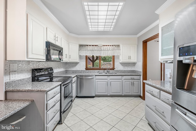 kitchen with appliances with stainless steel finishes, ornamental molding, sink, light tile patterned floors, and white cabinetry