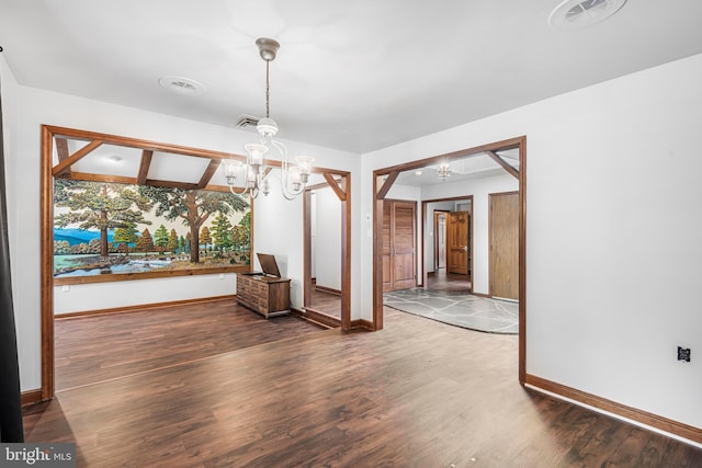 unfurnished dining area with beam ceiling, wood-type flooring, and an inviting chandelier