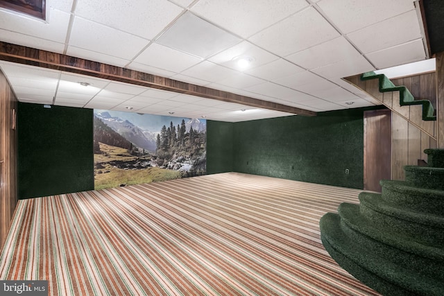 basement with a paneled ceiling and carpet floors