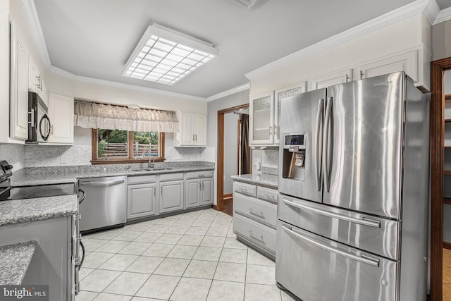 kitchen featuring backsplash, sink, gray cabinets, ornamental molding, and stainless steel appliances