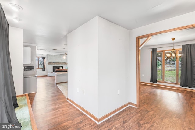 hall with hardwood / wood-style flooring and an inviting chandelier