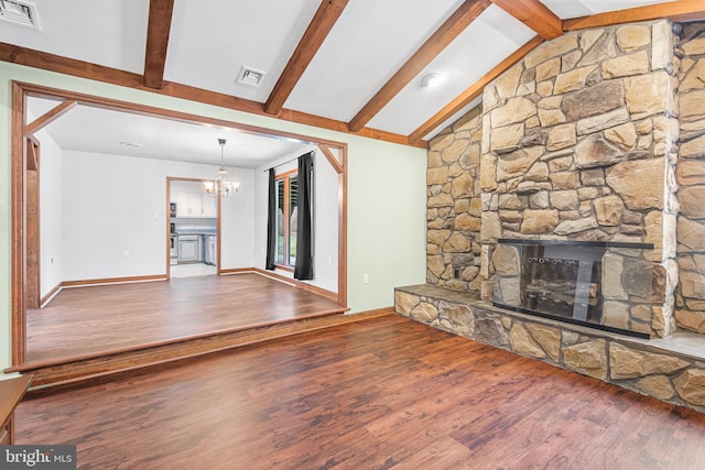 unfurnished living room featuring a notable chandelier, vaulted ceiling with beams, a stone fireplace, and wood-type flooring