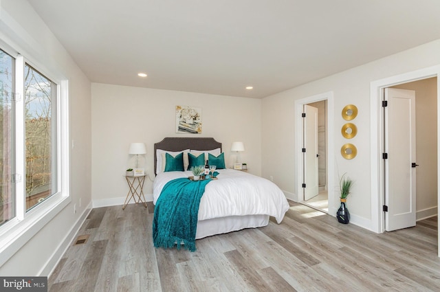 bedroom featuring light wood-type flooring and connected bathroom