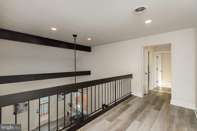 corridor featuring beamed ceiling and wood-type flooring