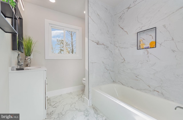 bathroom featuring vanity, toilet, and a tub to relax in