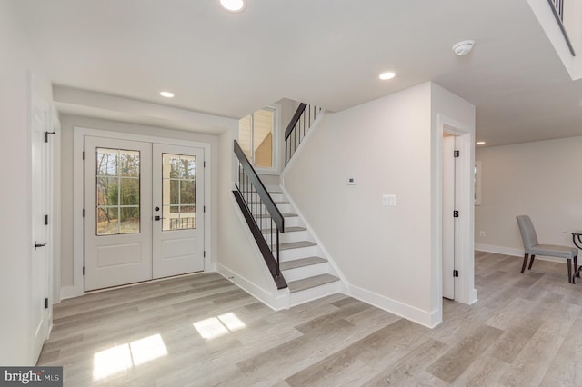 foyer entrance with light wood-type flooring and french doors