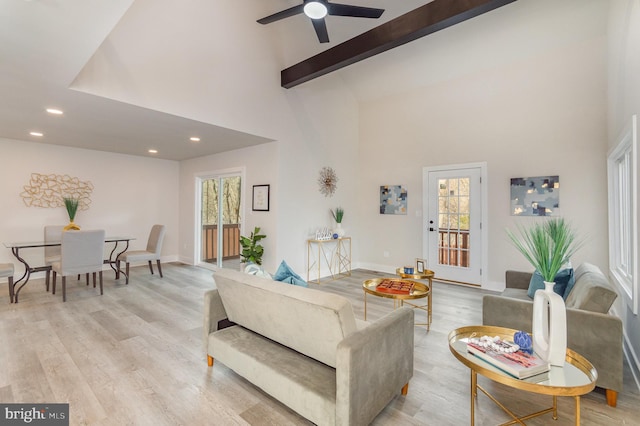 living room featuring ceiling fan, light hardwood / wood-style flooring, high vaulted ceiling, and beamed ceiling