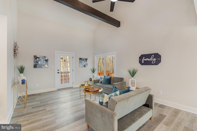 living room with beamed ceiling, high vaulted ceiling, light hardwood / wood-style flooring, and ceiling fan