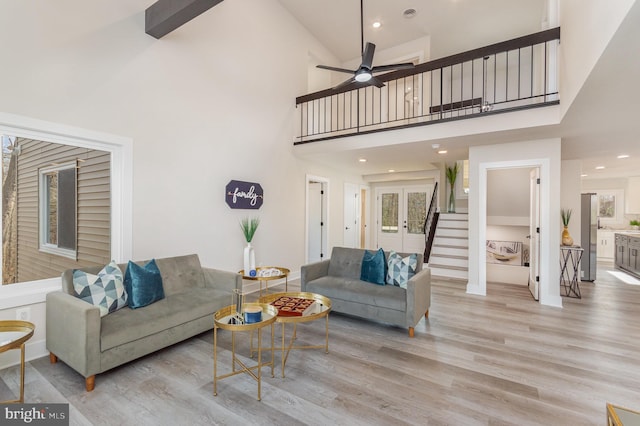 living room featuring ceiling fan, light wood-type flooring, and high vaulted ceiling