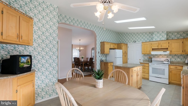 tiled dining area with ceiling fan with notable chandelier