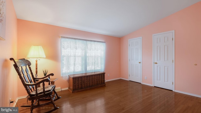 sitting room with dark hardwood / wood-style flooring and vaulted ceiling