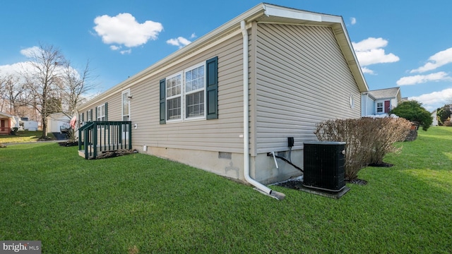 view of side of property featuring a lawn and central AC unit