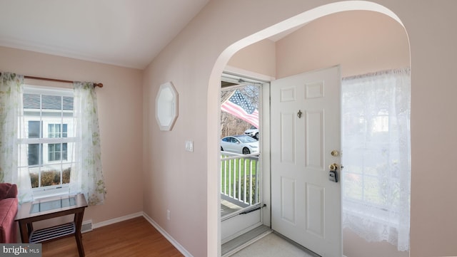 doorway to outside featuring wood-type flooring and vaulted ceiling