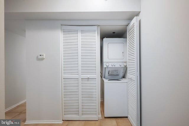 washroom with light tile patterned floors and stacked washer and clothes dryer