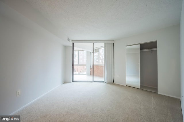 unfurnished bedroom with carpet flooring, a closet, and a textured ceiling