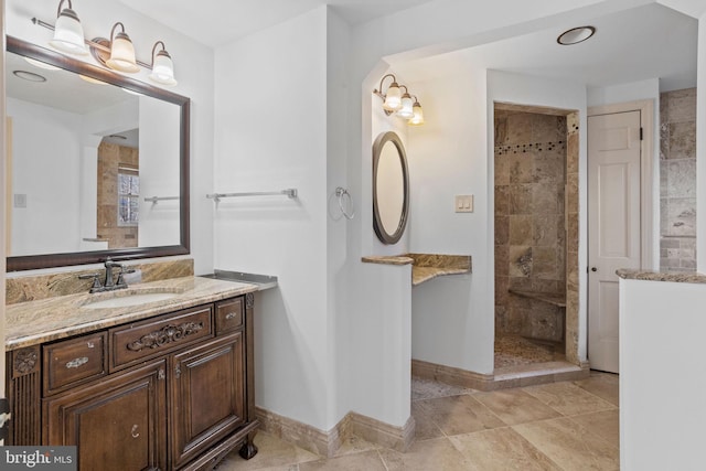 bathroom featuring tiled shower, vanity, and tile patterned floors