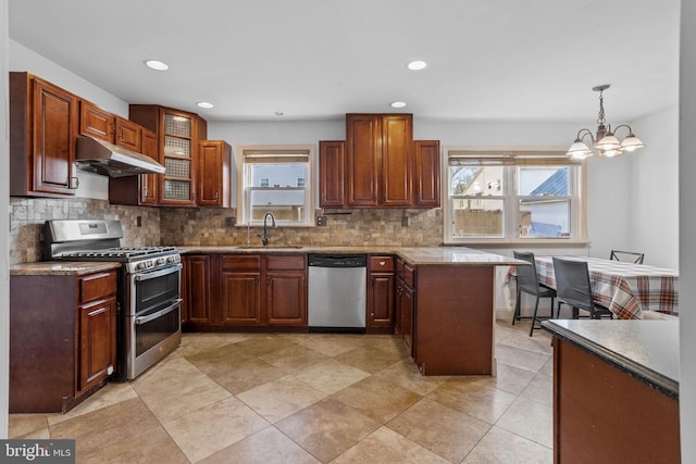 kitchen featuring a healthy amount of sunlight, sink, stainless steel appliances, and hanging light fixtures