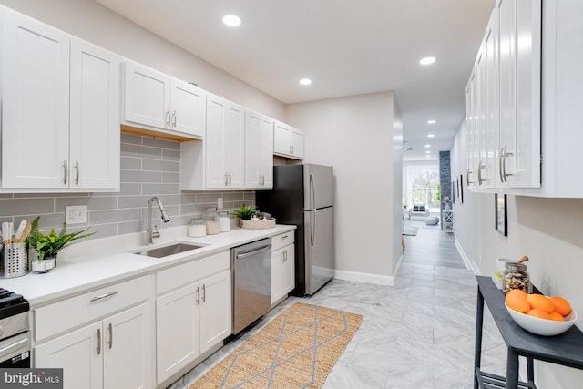 kitchen featuring tasteful backsplash, white cabinetry, sink, and appliances with stainless steel finishes