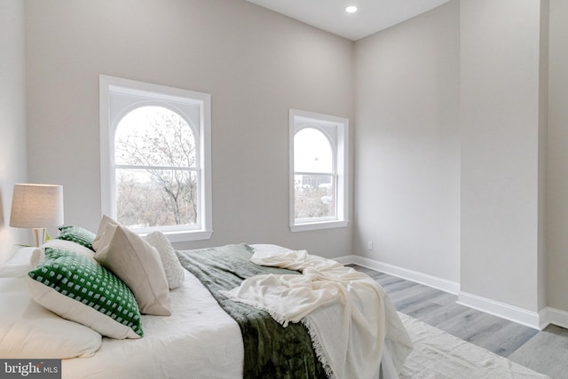 bedroom featuring light hardwood / wood-style flooring and multiple windows