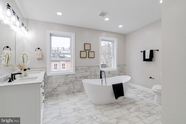 bathroom with a bathtub, toilet, tile walls, and vanity