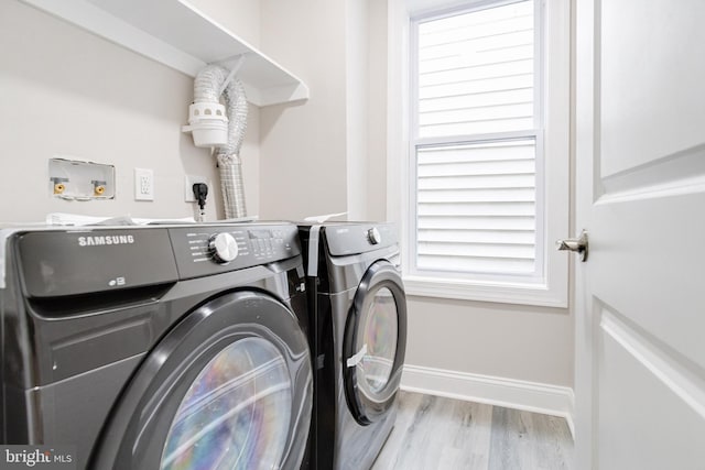 laundry room with plenty of natural light, light hardwood / wood-style floors, and washer and dryer