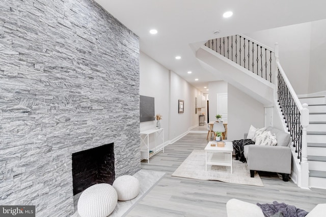 living room featuring light wood-type flooring and a fireplace