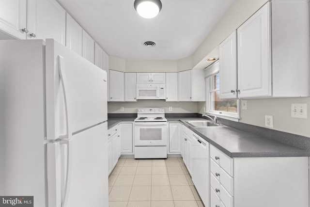 kitchen with light tile patterned floors, white appliances, white cabinetry, and sink