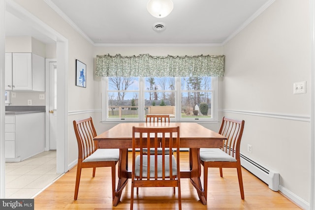 tiled dining space featuring ornamental molding and a baseboard radiator