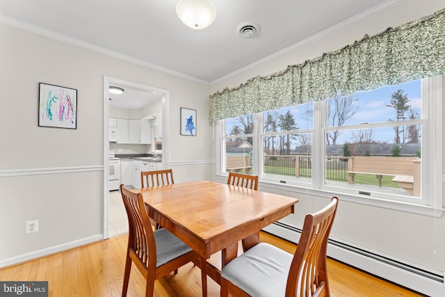 dining area with baseboard heating, crown molding, and light hardwood / wood-style flooring