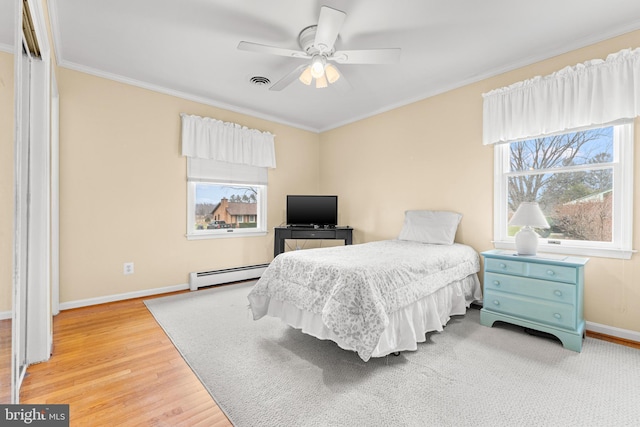 bedroom with multiple windows, ceiling fan, a baseboard radiator, and wood-type flooring