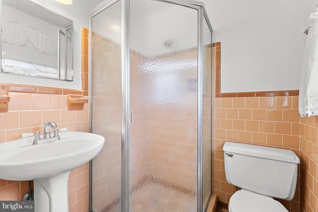 bathroom with toilet, tile walls, and walk in shower