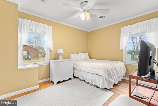 bedroom featuring ceiling fan, light hardwood / wood-style floors, and crown molding