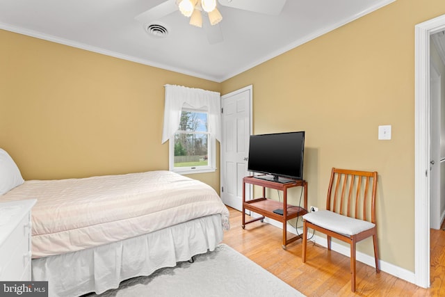 bedroom with ceiling fan, ornamental molding, and hardwood / wood-style flooring