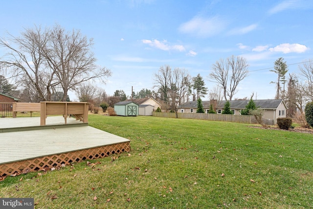 view of yard featuring a storage unit and a wooden deck