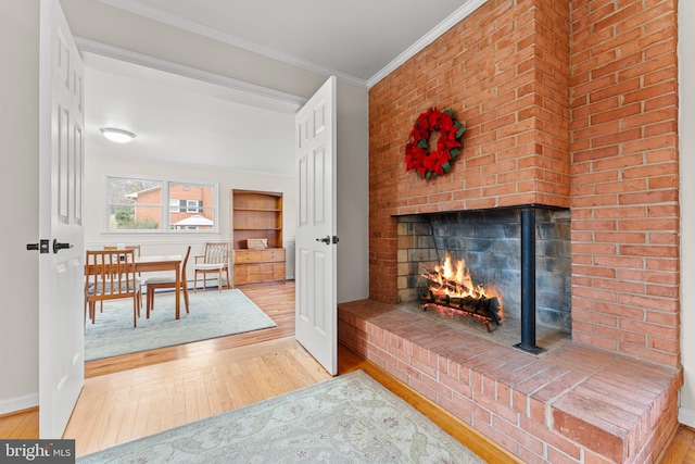 living room featuring a fireplace, crown molding, and hardwood / wood-style floors