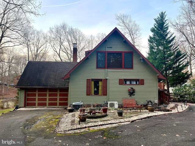 view of front of property featuring a garage and central AC unit